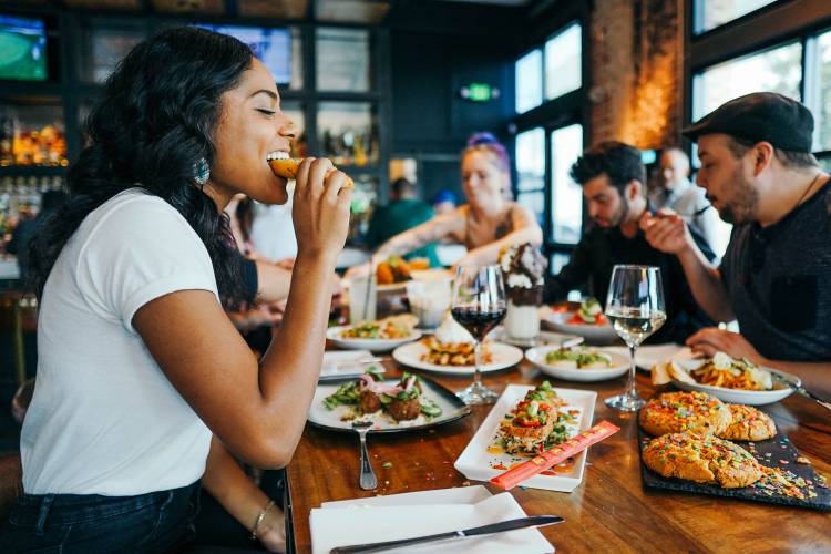 A group of friends sit at a table drinking beer at a local brewery