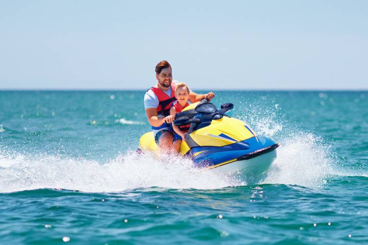 father and son riding a jet ski